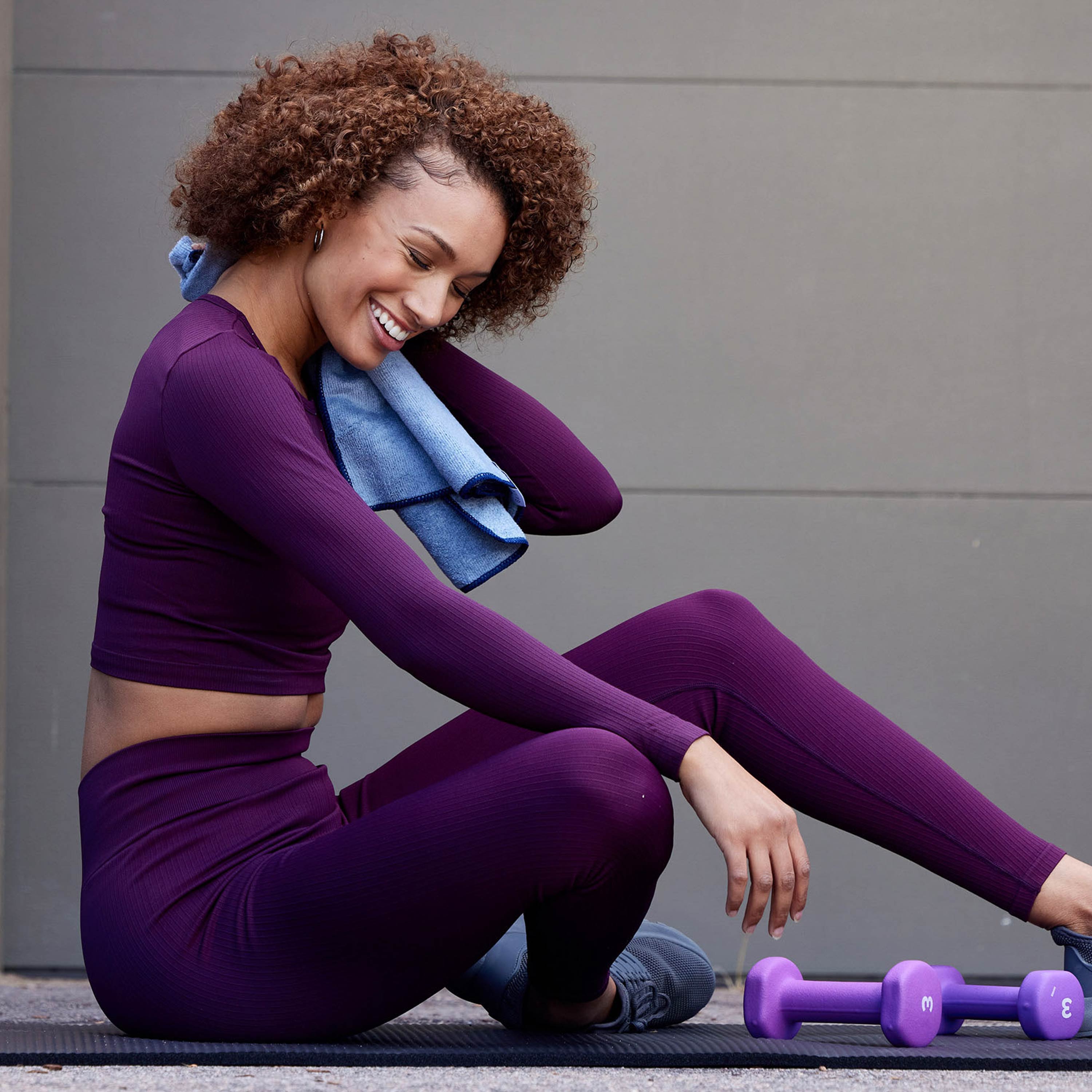 Person seated on mat using the Hand Towel to dry off back of neck